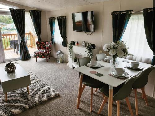 sala de estar con mesa blanca y sillas en Foxwood Lodge Private Hot Tub Getaway, en Swarland