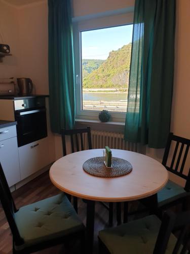 a table and chairs in a room with a window at Rheingold in Hirzenach