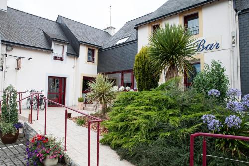 a building with a bunch of plants in front of it at Hotel Le Branhoc - Brit Hotel Auray in Auray