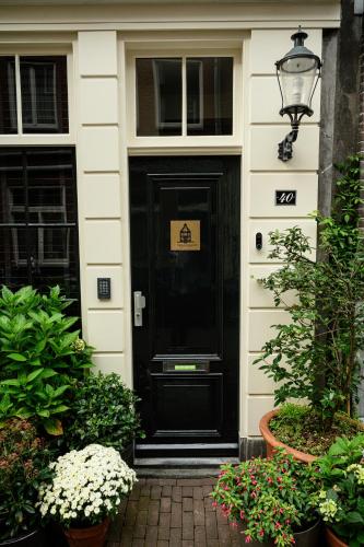 a black door of a house with a sign on it at The Blossom House Amsterdam in Amsterdam