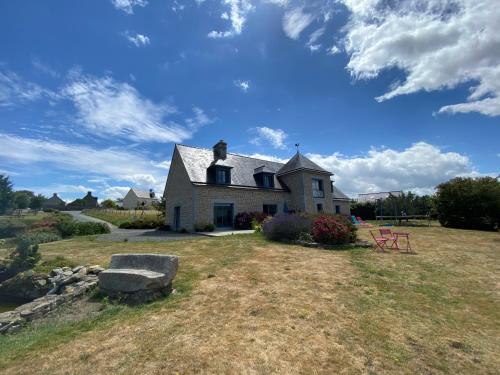una casa en un campo con un cielo azul en L'Aurore de la Baie, vue sur le Mont-Saint-Michel, en Huisnes-sur-Mer