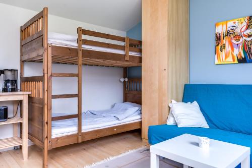 a bunk bed and a couch in a room at Cosy stay in southern Malmo in Malmö
