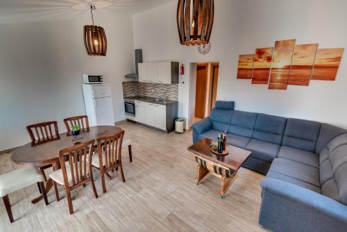sala de estar con sofá azul y mesa en Take A Break Apartments, en Brodarica