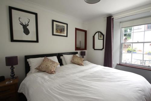 a bedroom with a large white bed with two pillows at The Wee Nook Birnam in Birnam