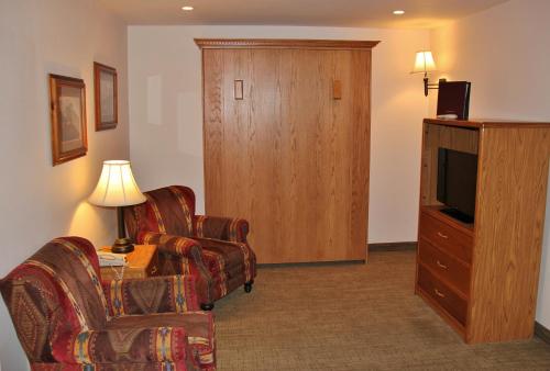 a living room with two chairs and a television at Homestead Inn and Suites in Hardin