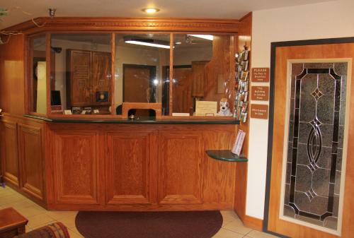 a bar with wooden cabinets and a mirror at Homestead Inn and Suites in Hardin