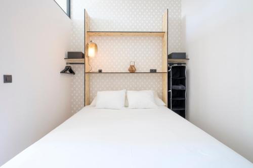 um quarto com uma cama com duas almofadas brancas em Fabulous studio in Châtelain area with balcony em Bruxelas