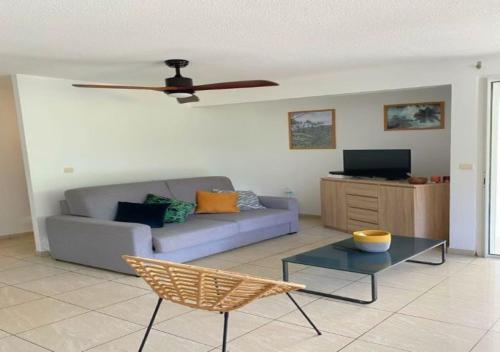 a living room with a couch and a ceiling fan at DOUC IRMA in Les Trois-Îlets
