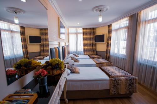 un groupe de quatre lits dans une pièce avec des fenêtres dans l'établissement Best Nobel Hotel, à Istanbul