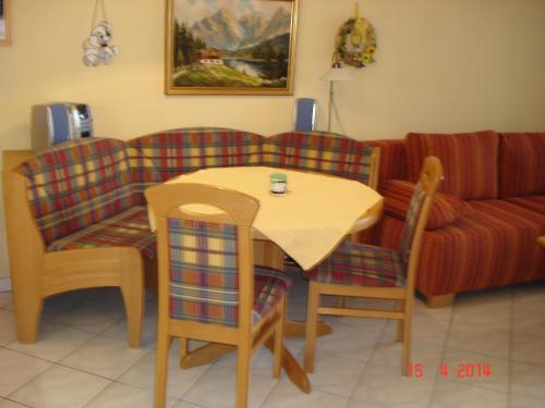 un soggiorno con tavolo, sedie e divano di Bad Füssing - Europa Residenz Suite 317 und Big Suite 307 a Bad Füssing