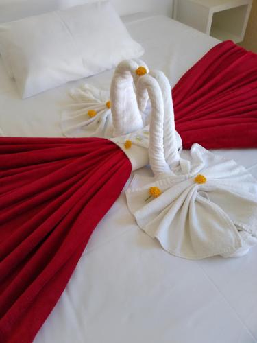 two towel swans are laying on a bed at HsHotelaria - Filial Bombinhas in Bombinhas
