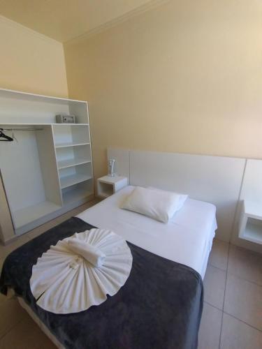 a room with a bed with an umbrella on it at HsHotelaria - Filial Bombinhas in Bombinhas