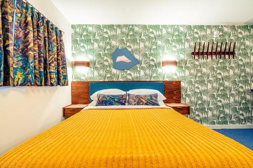a bedroom with a bed with a yellow bedspread at Classen Inn in Oklahoma City