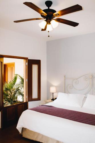 a bedroom with a bed with a ceiling fan at Hotel La Casona de Don Jorge in Colima
