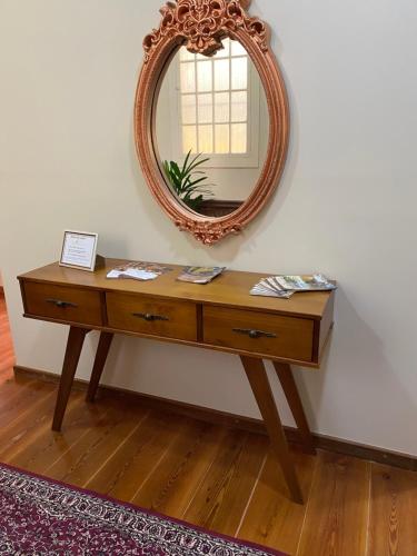 a dressing table with a mirror on a wall at Pousada Princesa Isabel - Visconde in Petrópolis