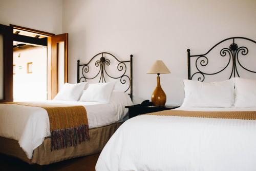 a bedroom with two beds and a mirror at Hotel La Casona de Don Jorge in Colima