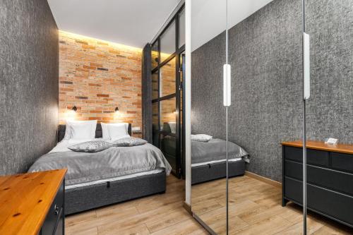 a bedroom with two beds and a mirror at Happy Stay Apartments Osiek in Gdańsk