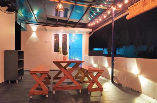 a dining room with two wooden tables and a blue door at Criston Home stay in Madurai