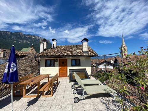 a house with a table and chairs on a patio at Goldengel Ferienwohnung im Herzen Kalterns mit einer Terasse zum verlieben in Caldaro