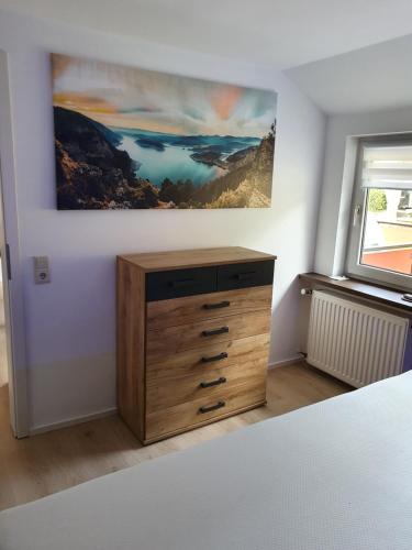 uma cómoda num quarto com uma pintura na parede em Zwischen den Talsperren em Marienheide