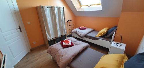 a small room with two beds and a window at Maison de campagne 6 personnes - "BIZYFAMILY" in Villermain