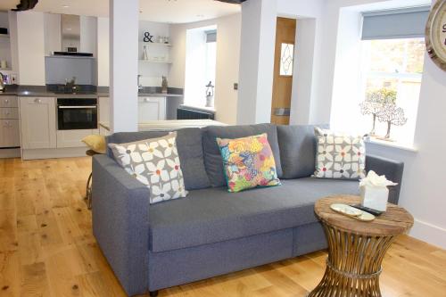 斯坦福德的住宿－1 The Cottage, Studio Apartment, Ye Olde Barn Apartments，客厅配有蓝色的沙发和桌子