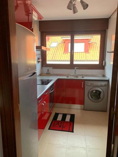 a kitchen with red cabinets and a washing machine at Apto Rio Asón, desconexión total con Piscina y vistas espectaculares in Gibaja