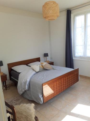 a bedroom with a bed with a wooden headboard at Les Charmettes in Mers-les-Bains