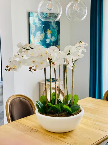 a white plant in a white bowl on a table at Villa le Fontanelle in Gasperina