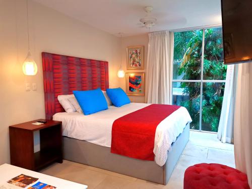 a bedroom with a bed with a red headboard and a window at Jungle Vista Boutique Hotel in Manuel Antonio