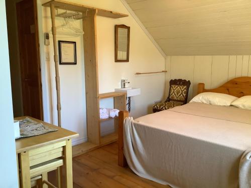 1 dormitorio con 1 cama, 1 mesa y 1 silla en Gite chez Gilles Lévesque, en Saints-Anges