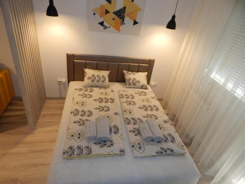 um quarto com uma cama com duas almofadas em Pisztácia 2020 Apartman em Kazincbarcika