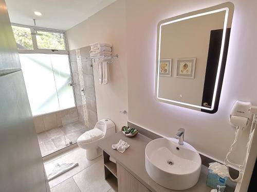 a white bathroom with a sink and a mirror at Jungle Vista Boutique Hotel in Manuel Antonio