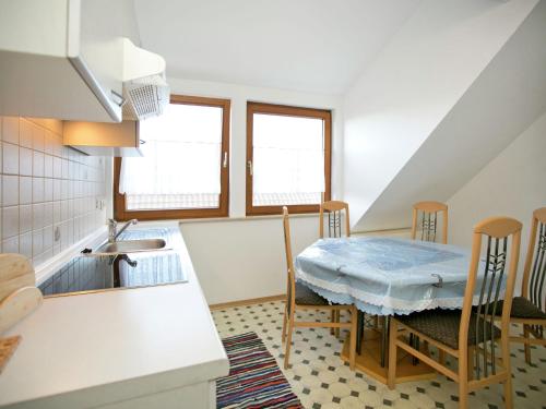 Spacious apartment near Lake Constance في Ahausen: مطبخ مع طاولة وكراسي ومغسلة
