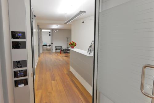 an office with a hallway with wood floors and white walls at Residence Del Messaggero in Rovereto