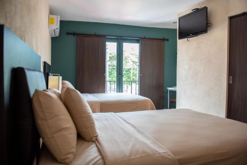 a hotel room with two beds and a television at Hotel Casa Real in Villahermosa
