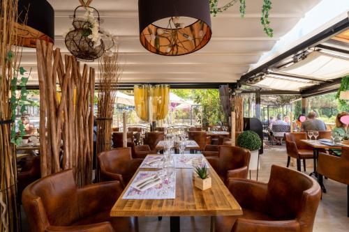 un restaurant avec une table et des chaises en bois dans l'établissement Hotel Restaurant Bellevue, à Bormes-les-Mimosas