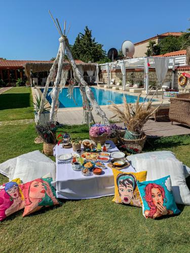ein Tisch mit Tellern voller Essen neben einem Pool in der Unterkunft Kemerlihan Deluxe Hotel in Alacati
