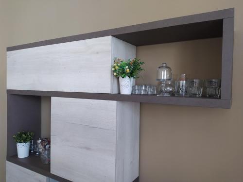 a wooden shelf with flowers and vases on it at TOSCANA HOME in Ravenna