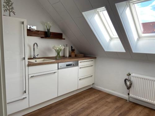 a kitchen with white cabinets and two skylights at Luxuriöse 3-Zi. Ferienwohnung Jagdromantik 200 m bis zur Wurmbergsseilbahn in Braunlage