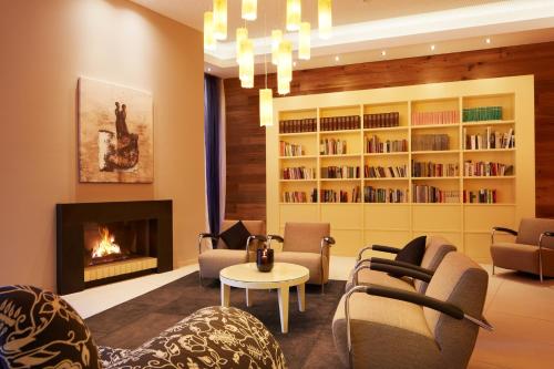 a living room with a fireplace and chairs and a fire place at Best Western Premier Park Hotel & Spa in Bad Lippspringe