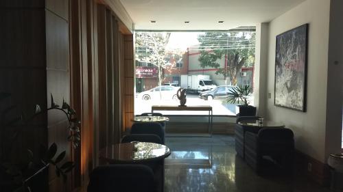 a room with tables and chairs and a large window at Castel Plaza Hotel in Resende