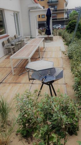 a picnic table and a grill on a patio at Zeeparel XL in Koksijde