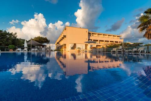 un hotel con piscina frente a un edificio en Hotel Tahiti en Es Pujols