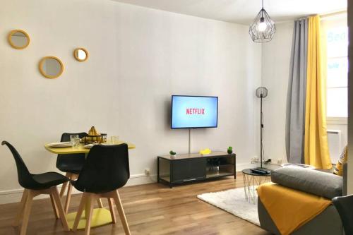 a living room with a couch and a tv on a wall at Luxury-Centre-Ville -Gare-netflix Wifi in Niort