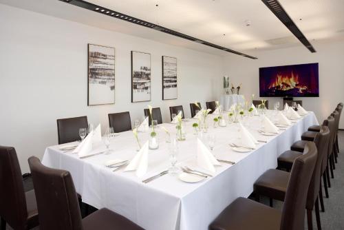 a long white table in a room with chairs at Schlossberg Hotel Homburg in Homburg