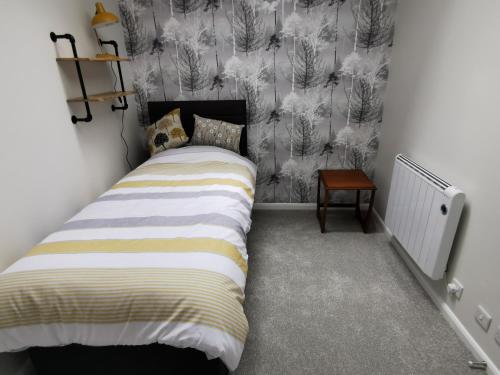 Dormitorio pequeño con cama y pared en Chapel Cottage en Oundle