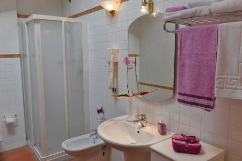 a bathroom with a sink and a shower with purple towels at Residence Del Messaggero in Rovereto