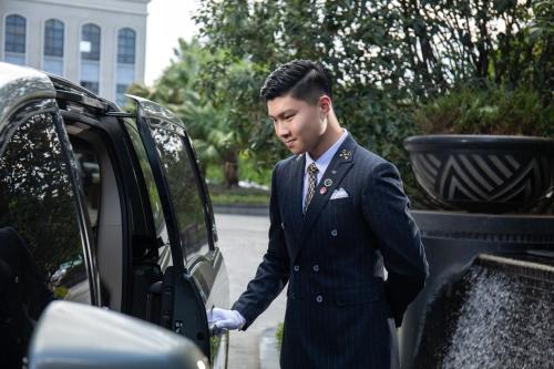 a man in a suit getting out of a car at Crowne Plaza Fuzhou South by IHG in Fuzhou