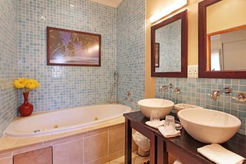 a bathroom with a tub and a sink and a mirror at Kleinbosch Lodge in Stellenbosch